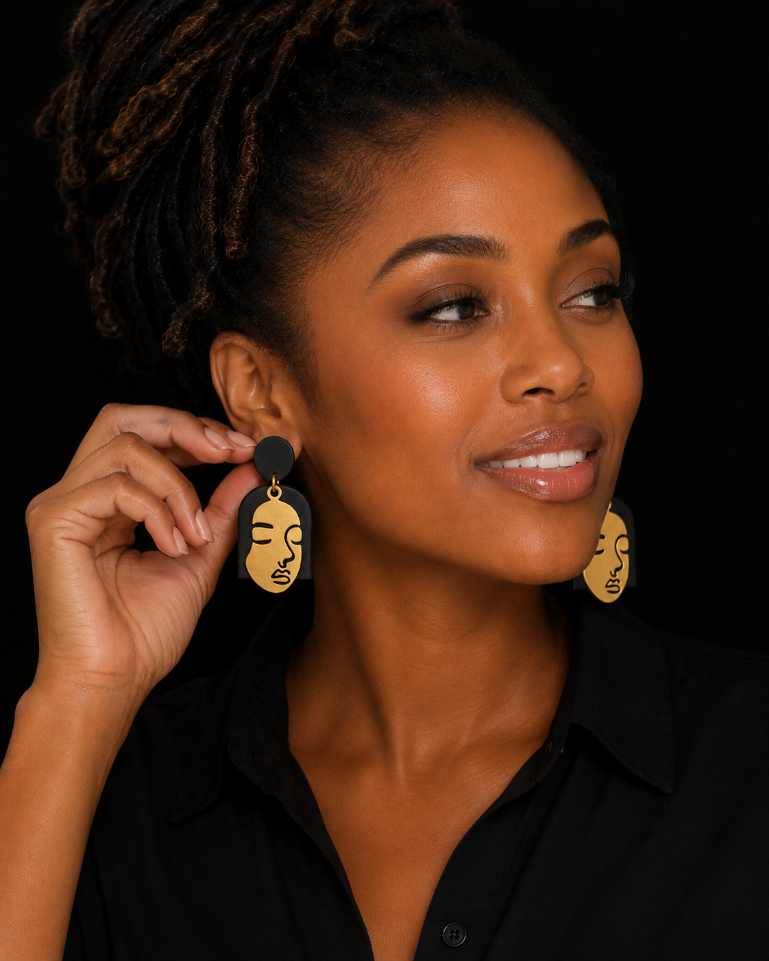 Model wearing gold face statement earrings