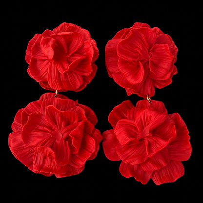 Four red flower-shaped earrings arranged in a 2x2 grid on a solid black background.